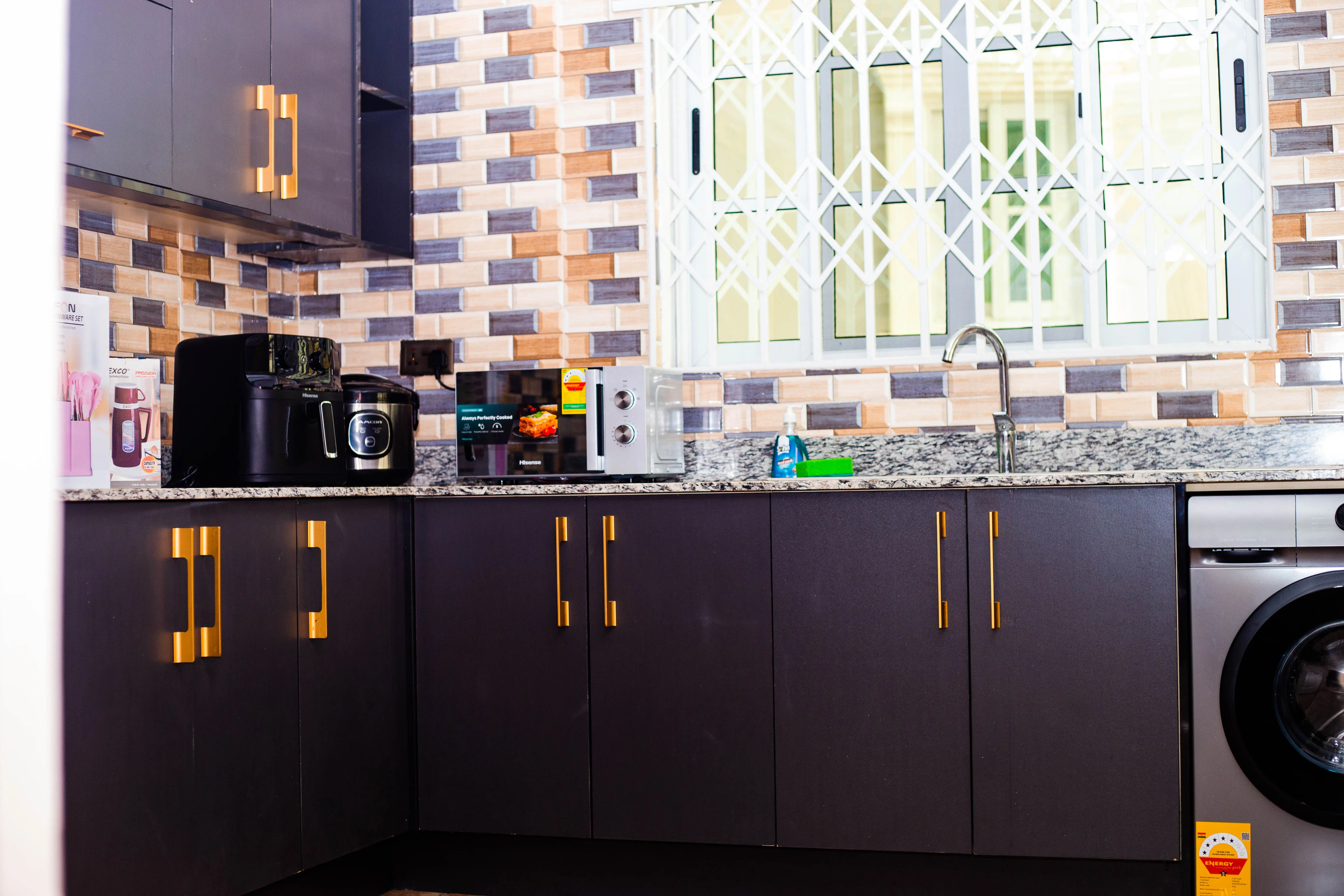 Equipped kitchen with dark cabinetry and gold handles