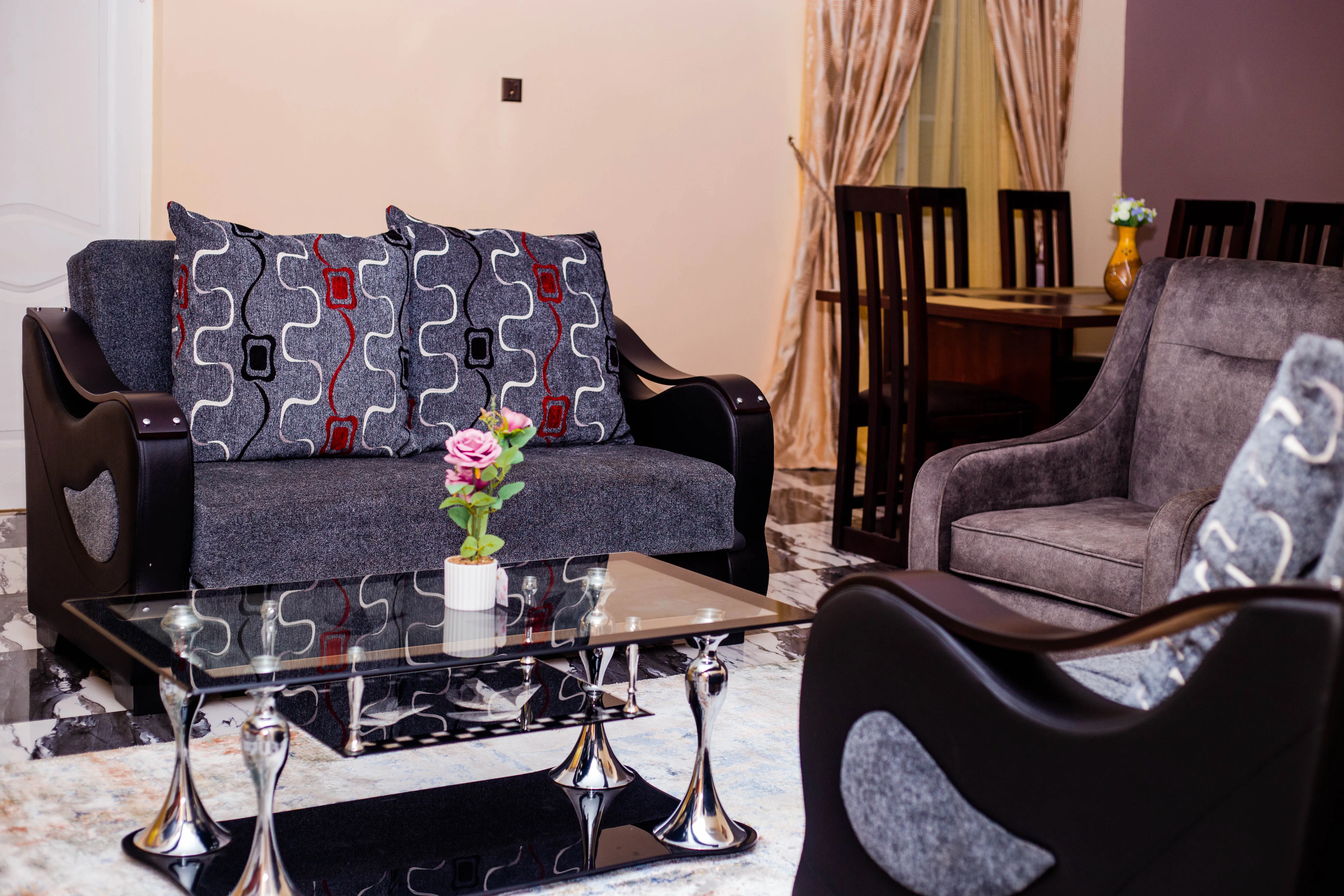 Grey furnished sitting room with dining space beyond